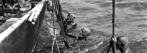 Pearl divers working beside a boat in Bahrain