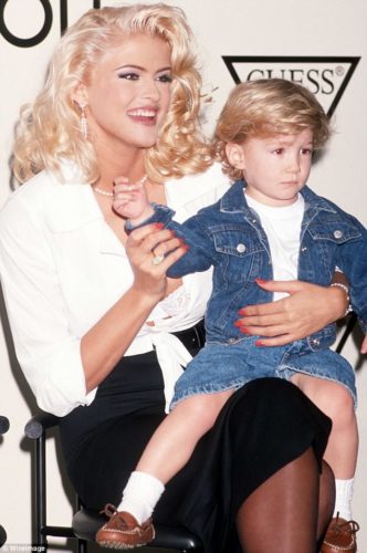 Anna Nicole Smith wearing a strand of pearls and dangling pearl earrings. That's her son Daniel (RIP) sitting on her lap.