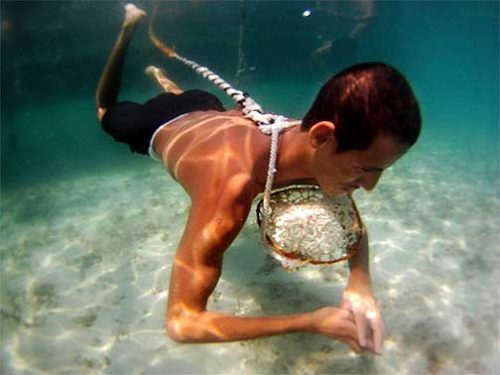 Man uses rope and basket to help with his pearl diving venture.