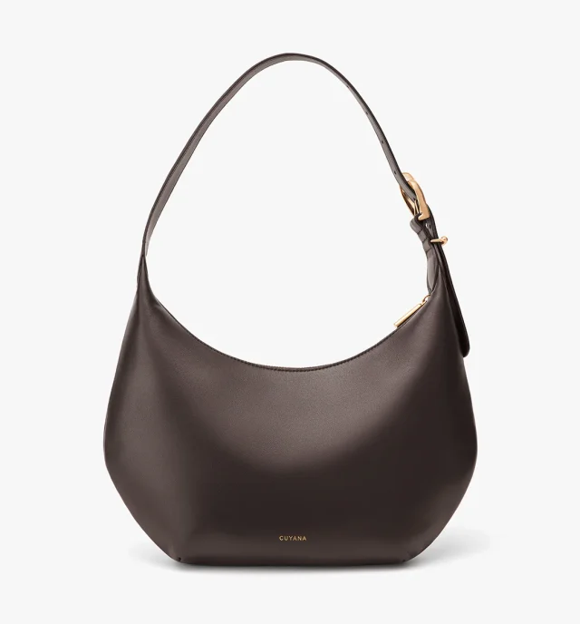 A crescent-shaped shoulder bag in brown napa leather form Cuyana.